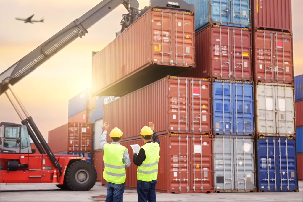 Foremen are working at container depot to manage inventory on yard.